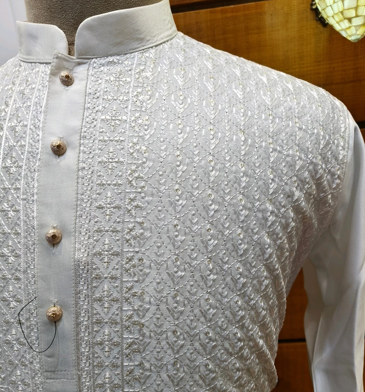 White embroidered shirt with buttons on a wooden mannequin