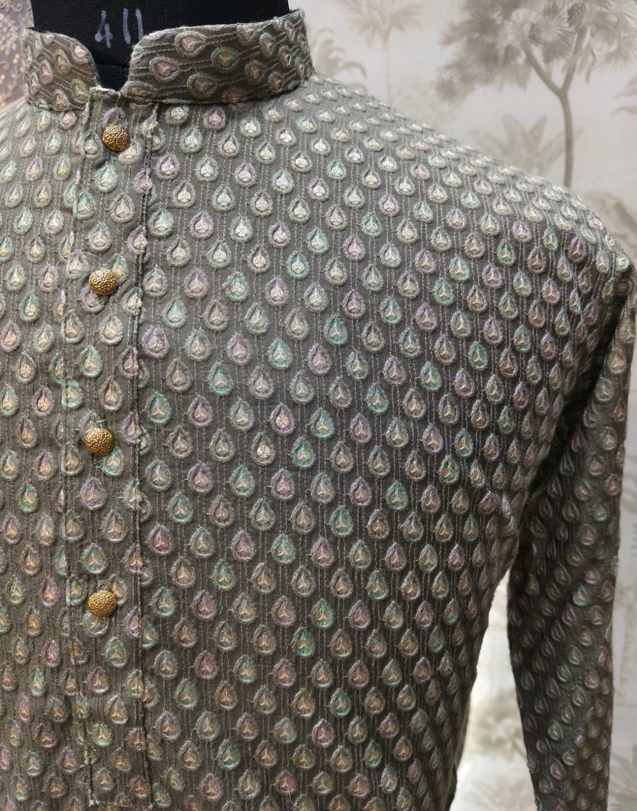 Close-up of a patterned shirt with buttons against a neutral background