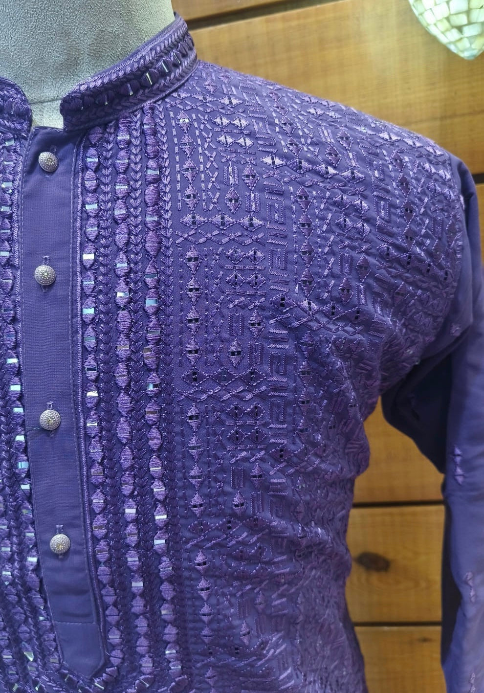 Close-up of a purple embroidered garment on a wooden surface