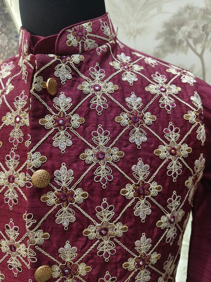 Maroon embroidered garment on a mannequin with a white background