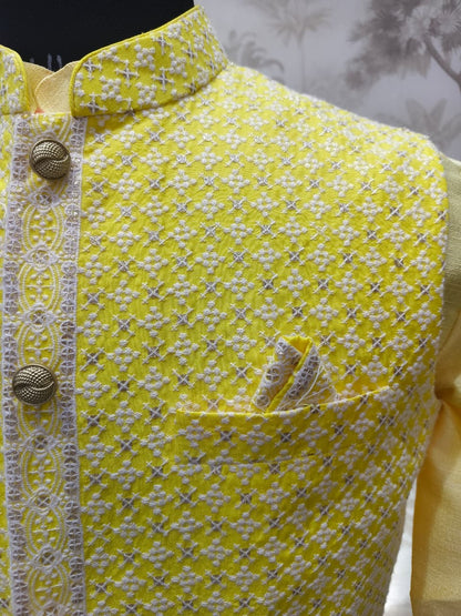 Yellow garment with white floral pattern and decorative buttons on a blurred background