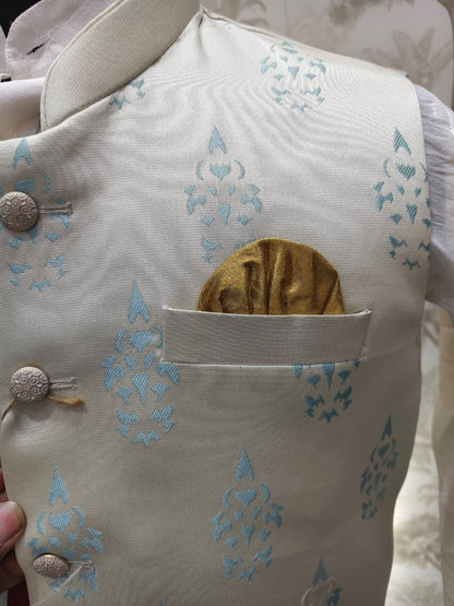 Light-colored garment with blue patterns and a gold pocket detail.