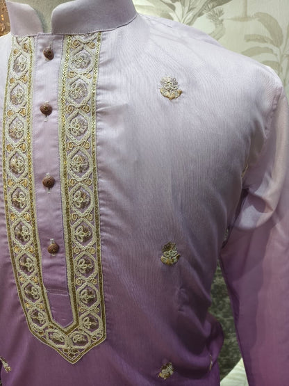 Purple shirt with gold embroidery on a mannequin against a floral background
