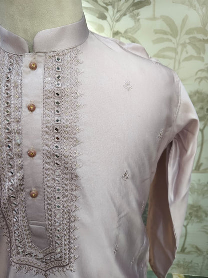 PINK kurta with intricate embroidery on a mannequin against a floral wallpaper background