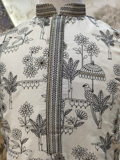 Embroidered garment with floral and bird patterns on a neutral background