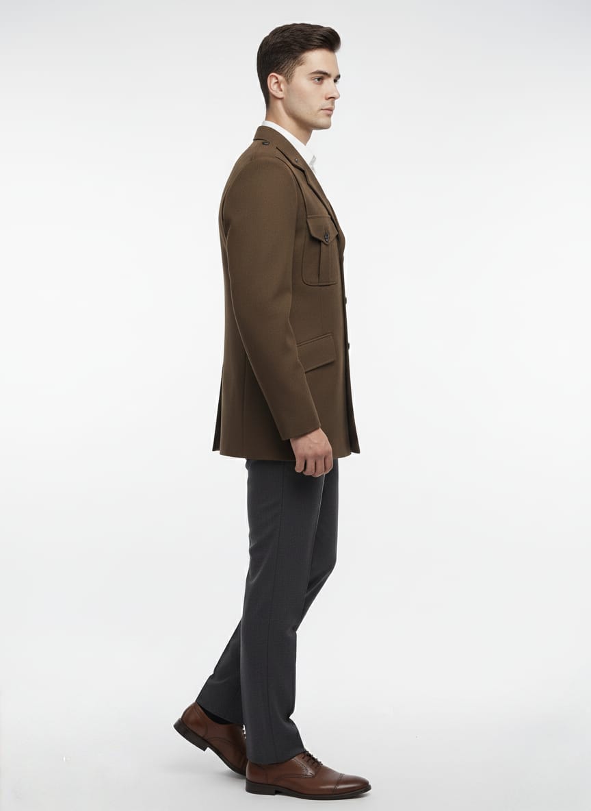 Man wearing a brown coat and gray pants on a white background