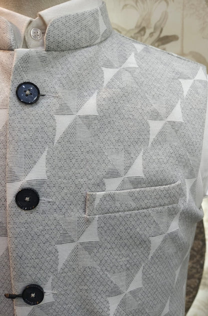 Close-up of a gray patterned shirt with black buttons on a neutral background